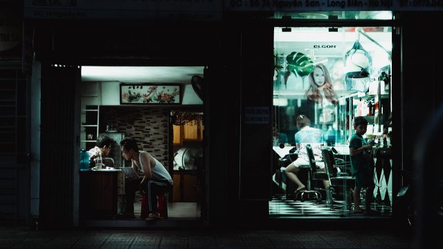 电影免费在线观看网站飘花 夜晚城市街景的电影剧照，霓虹灯映在湿漉漉的路面上，画面偏冷色调，氛围安静而克制